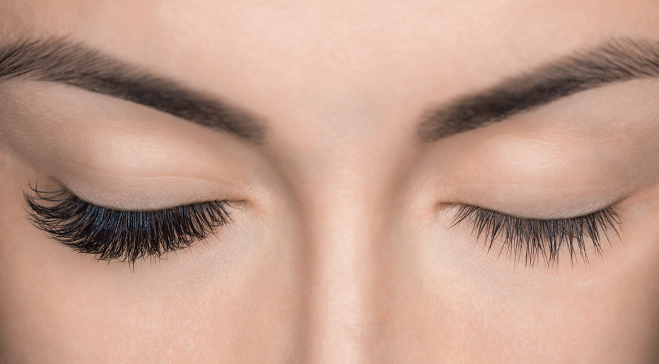 Eyelash removal procedure close up. Beautiful Woman with long lashes in a beauty salon. Eyelash extension.